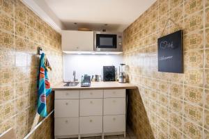 a small kitchen with white cabinets and a counter at Briller Gewölbe in Wuppertal +15 photos