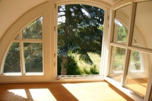an empty room with two large windows with a view at Kate unter Reet im Grünen in Buchholz +5 photos