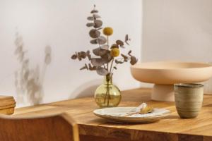 a wooden table with a vase with flowers in it at Briller Gewölbe in Wuppertal