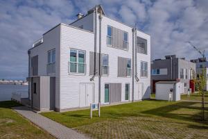 a large white building on the side of a body of water at Lootsen Hus by Seeblick Ferien in Olpenitz