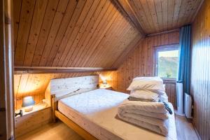 a bedroom with a bed in a wooden room at Le Chalet Jarrier in Jarrier