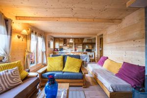 a living room with wooden walls and couches at Le Chalet Jarrier in Jarrier