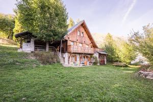 a large wooden house on a grassy field at Le Chalet Jarrier in Jarrier