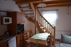 a kitchen with a dining room table and a staircase at Chata Eliška in Loučná nad Desnou