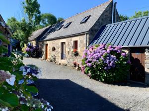 a stone building with flowers in front of it at Ensemble De Gites - Pen Ar Voas in Plestin-les-Grèves