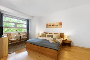 a bedroom with a bed and a table and a window at Albrechtshof in Potsdam