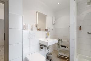 a white bathroom with a sink and a mirror at Auszeit am Schloss in Geisenheim +15 photos