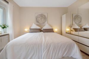 a white bedroom with a large white bed with pillows at Auszeit am Schloss in Geisenheim