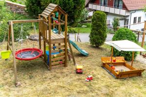 a playground with a slide and a swing at Haus Am Waldrand in Schenkenzell