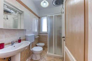 a bathroom with a toilet and a sink and a shower at E case e Leviche in Castrignano del Capo +12 photos