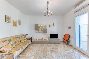 a living room with a couch and a tv at E case e Leviche in Castrignano del Capo
