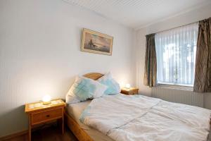 a bedroom with a bed with two night stands and a window at Ferienwohnung 'Ferien bei Buske' in Tellingstedt