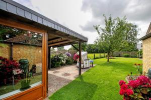 a garden with a pavilion and a lawn with flowers at Ferienwohnung 'Ferien bei Buske' in Tellingstedt +12 photos