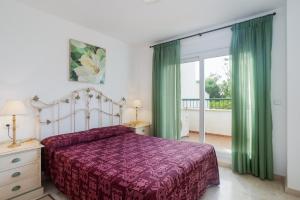 a bedroom with a bed with a purple bedspread at Guadalmina Baja in Marbella +19 photos