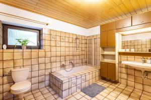 a bathroom with a tub and a toilet and a sink at Haus Waldesruh in Medebach +32 photos