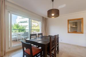 a dining room with a table and chairs and a window at Guadalmina Baja in Marbella