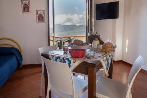 a dining room with a table and chairs with a view at Casa Arconides in Motta D'affermo