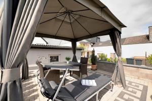 een terras met een parasol, een tafel en stoelen bij Bellevie in Kell