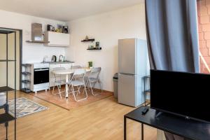 a living room with a kitchen with a table and a refrigerator at Apartment Magdeburg in Magdeburg +12 photos