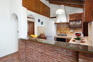 a kitchen with a brick counter and a brick wall at Cortijo Salva in Periana