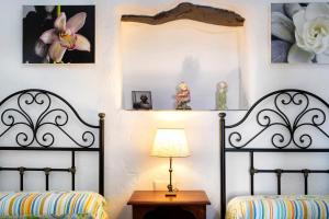 two beds in a room with a table and a lamp at Cortijo Salva in Periana