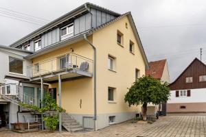 a yellow building with a staircase on it at Fewo unter der Kirche in Herbolzheim