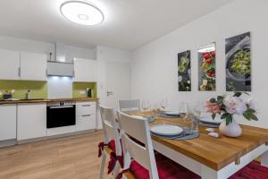 a kitchen and dining room with a wooden table and chairs at Fewo unter der Kirche in Herbolzheim