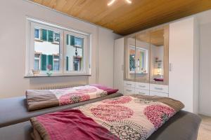 a bedroom with two beds and a mirror at Fewo unter der Kirche in Herbolzheim +20 photos