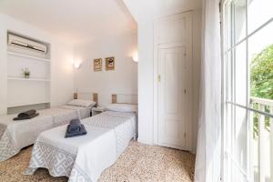 three beds in a room with a window at Hostal Moya in Roquetas de Mar