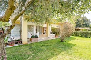a house with a yard with a tree at Villa Le Maree di Tonfano in Pietrasanta