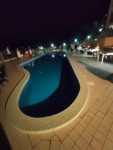 a swimming pool at night with people standing around it at Frisaia F3 in Isola Rossa