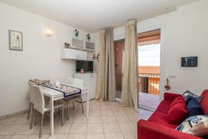 a living room with a red couch and a table at Frisaia F3 in Isola Rossa