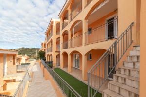 an apartment building with balconies and a walkway at Frisaia F3 in Isola Rossa