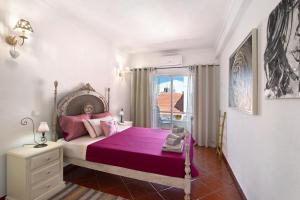 a bedroom with a large bed with a purple blanket at Casa Terracota in Silves