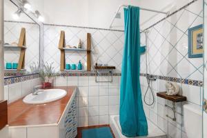 a bathroom with a sink and a blue shower curtain at Casa Terracota in Silves +22 photos