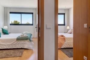 a bedroom with two beds and two windows at Sublime Mundo Apartamento in Apúlia +18 photos