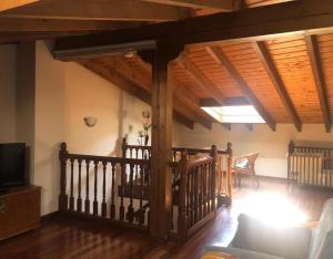 a living room with a wooden staircase and a tv at Juderia I in Oña