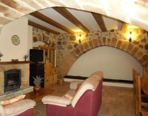 a living room with a stone fireplace and couches at Juderia I in Oña +12 photos