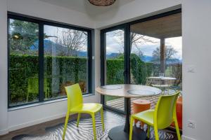 a room with windows and a table and chairs at Appart bureau in Le Touvet