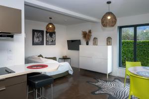 a bedroom with a bed and a kitchen with a table at Appart bureau in Le Touvet