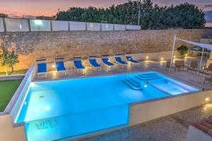a swimming pool with blue lighting on a building at Villa Vani - Appartamento 2 in Marina di Ragusa