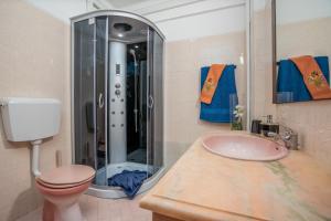 a bathroom with a shower and a toilet and a sink at Apartamento Escadinhas in Lagos +19 photos