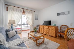 a living room with a blue couch and a tv at Apartamento Escadinhas in Lagos