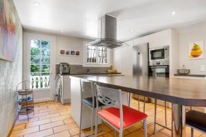 a kitchen with a large counter and a red chair at Maison - La Lieutenante in Puget-sur-Argens