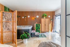 a bathroom with a tub and plants in it at Une parenthèse en luberon, jacuzzi in Les Taillades