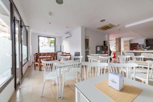 a restaurant with white tables and white chairs at Hostal Moya in Roquetas de Mar