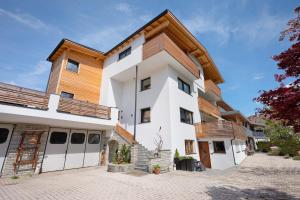 a large white building with a wooden roof at Haus Mader 3 in Riscone
