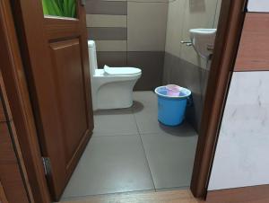 a bathroom with a toilet and a trash can at Alhind Residency , Valara, Munnar in Munnar