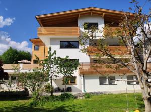 a white building with wooden roof at Haus Mader 3 in Riscone