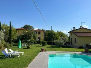 a backyard with a swimming pool and a house at Papà Giuseppe La Cantina in Cortona